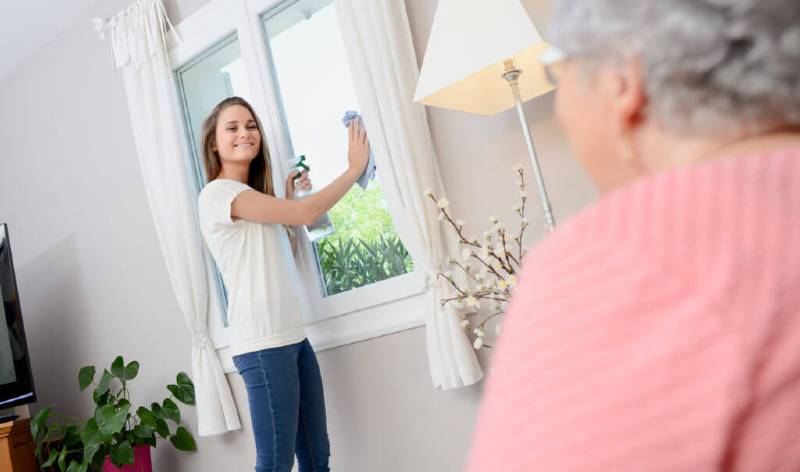 Women helping senior in cleaning