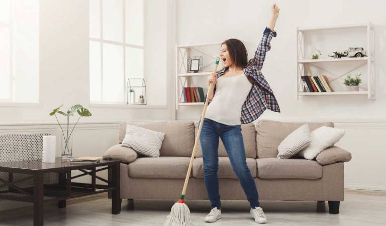 Woman finding motivation for cleaning inside a room