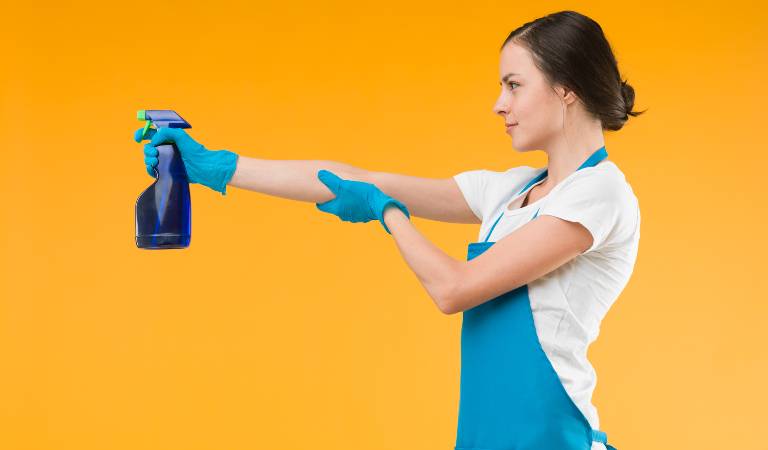 Woman in white-blue dress holding a black bottle in her hand.