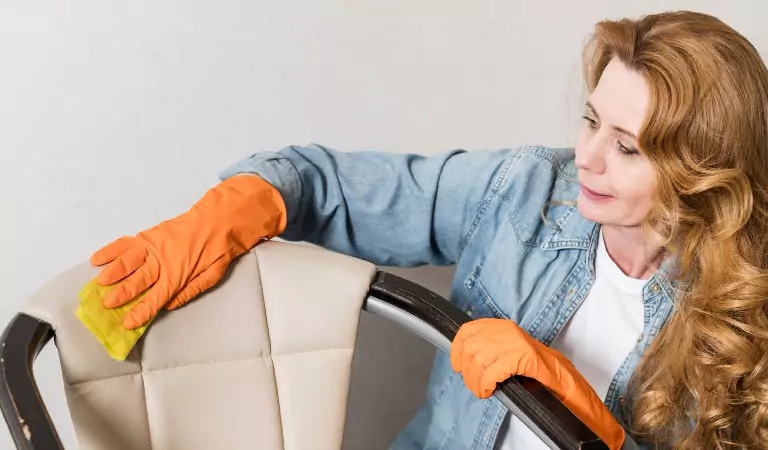 young woman wiping a leather furniture with a mop