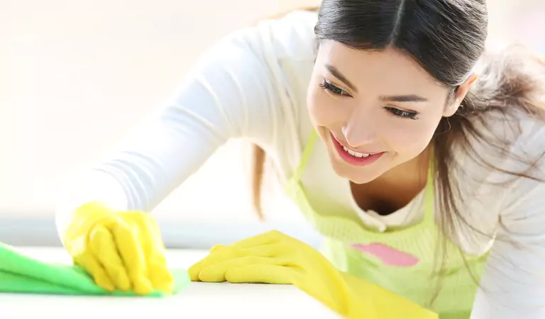 young woman disinfecting a household surface