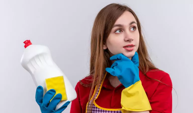 young woman holding a chemical cleaner in hand and ready to clean
