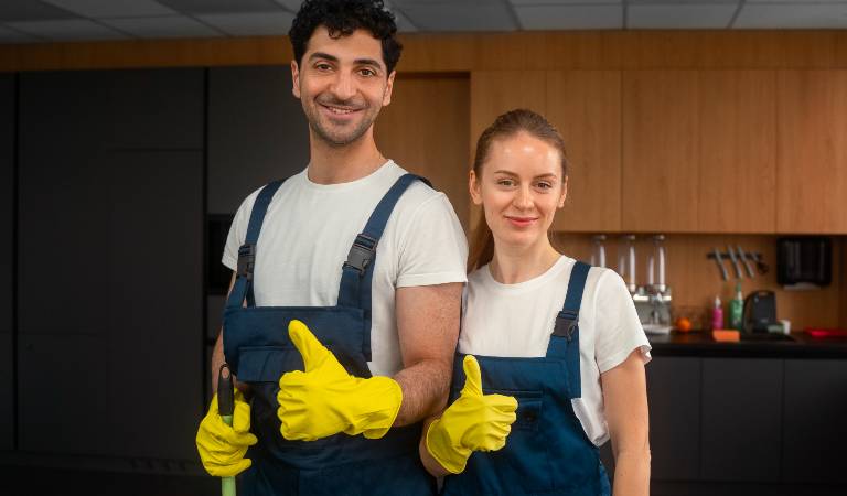 Man and a woman in uniform and yellow gloves showing thumps up