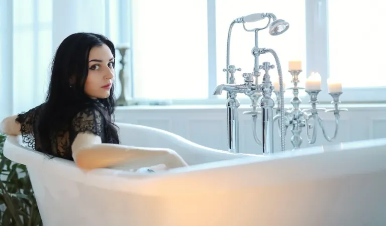 Woman in black top sitting in her spa bathtub