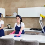Cleaning service team at work in kitchen in private home