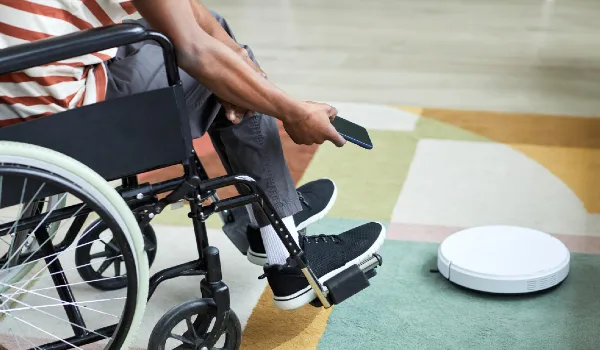 Man with disability using accessible smart vacuum
