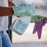 Cleaning door handle and sanitize with a woman cleaner in a home
