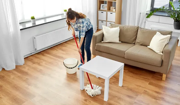 Woman or housewife with mop cleaning floor at home
