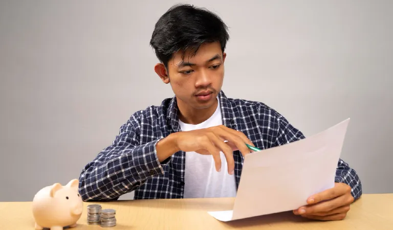 A young man is writing and organize his money