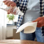 Woman degreasing old table surface